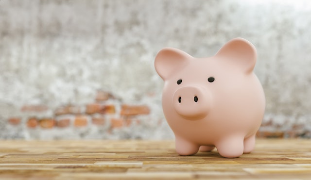 piggy-bank-on-a-table-in-front-of-a-brick-wall piggy-bank-on-a-table-in-front-of-a-brick-wall