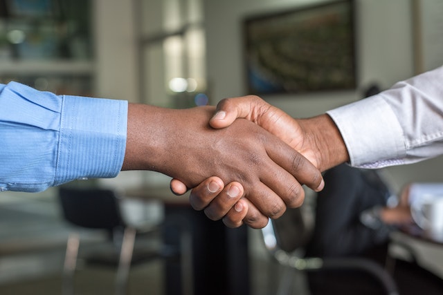 two-people-wearing-long-sleeves-shirts-shaking-hands two-people-wearing-long-sleeves-shirts-shaking-hands