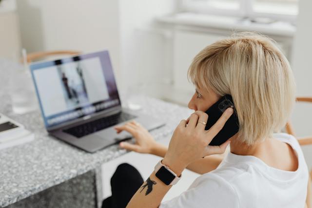 person-sitting-at-a-table-working-on-their-computer-talking-on-the-phone-with-a-property-manager person-sitting-at-a-table-working-on-their-computer-talking-on-the-phone-with-a-property-manager