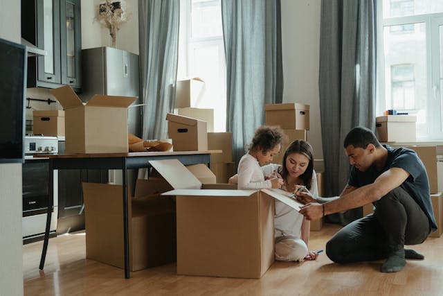 family-of-three-unpacking-and-playing-in-boxes-while-moving-in family-of-three-unpacking-and-playing-in-boxes-while-moving-in