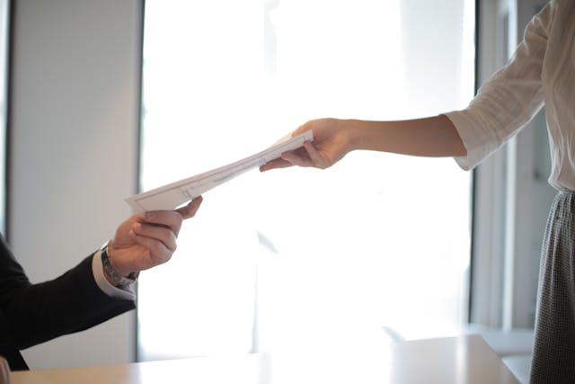 pexels-olly-3760072 two people exchanging a piece of paper